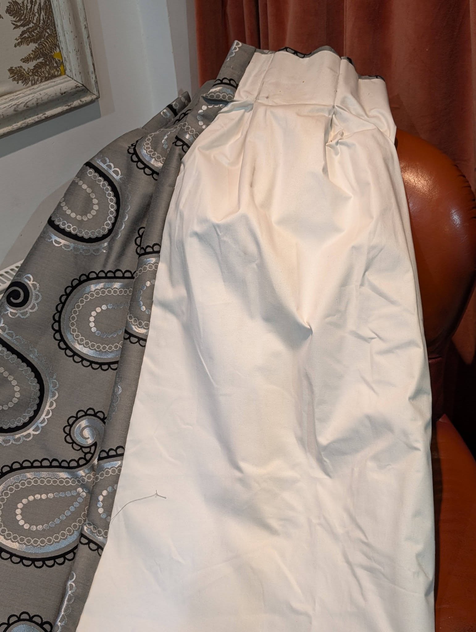 rach16 - Divinely Vintage Interiors Gray fabric with circular lace-like patterns draped over a white sheet near a window frame.