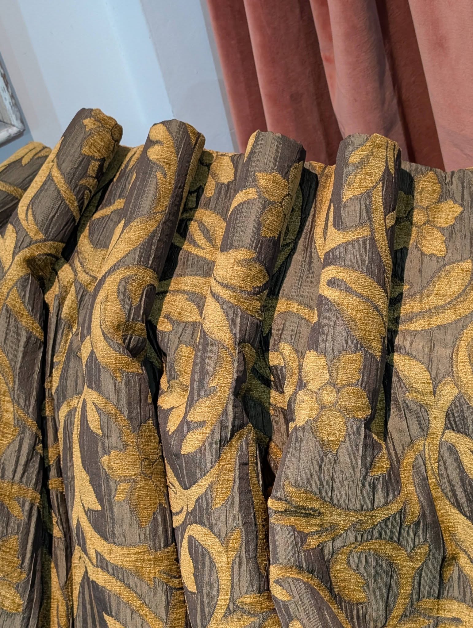 rachel6 - Divinely Vintage Interiors Close-up of grey drapery with a gold leaf pattern on it, showing textured fabric and folds.