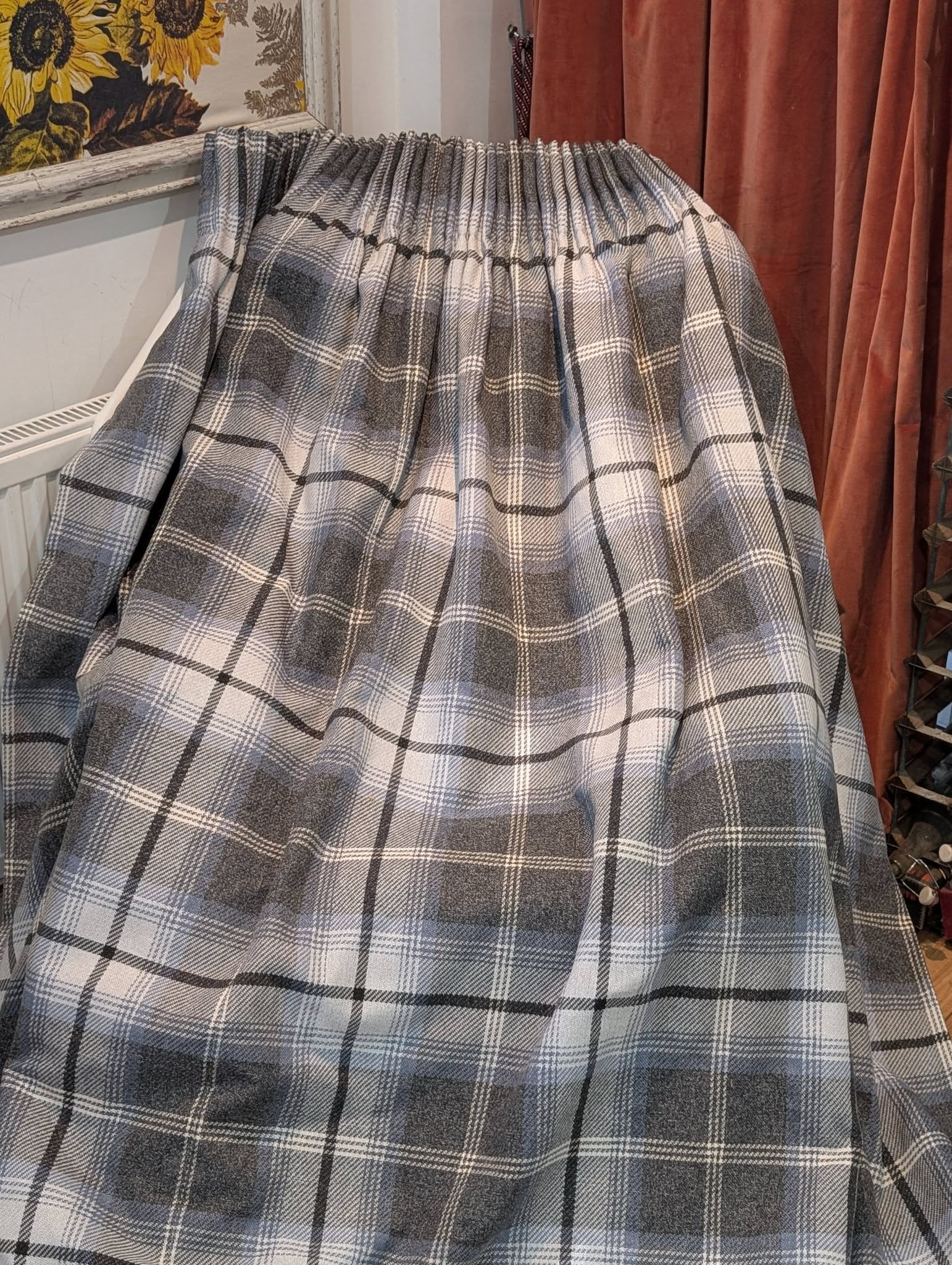richard3 - Divinely Vintage Interiors Gray plaid wool blanket draped over an object in a room with sunflower wallpaper and brown curtains