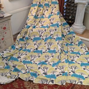 Chair draped with a bright blue, lime, and navy floral-patterned throw in a vintage-style living room setting.