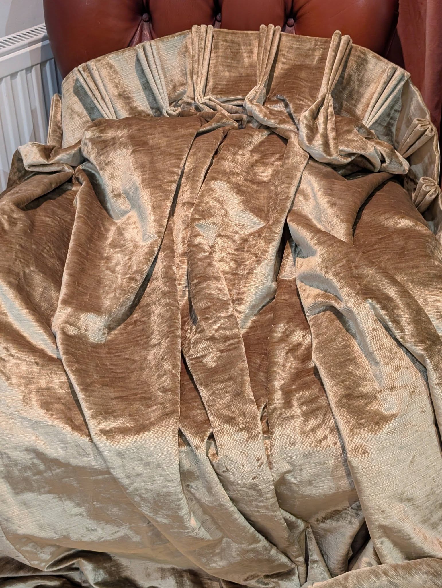 judith11 - Divinely Vintage Interiors Gold-beige crushed velvet draped over a chair, forming large folds.