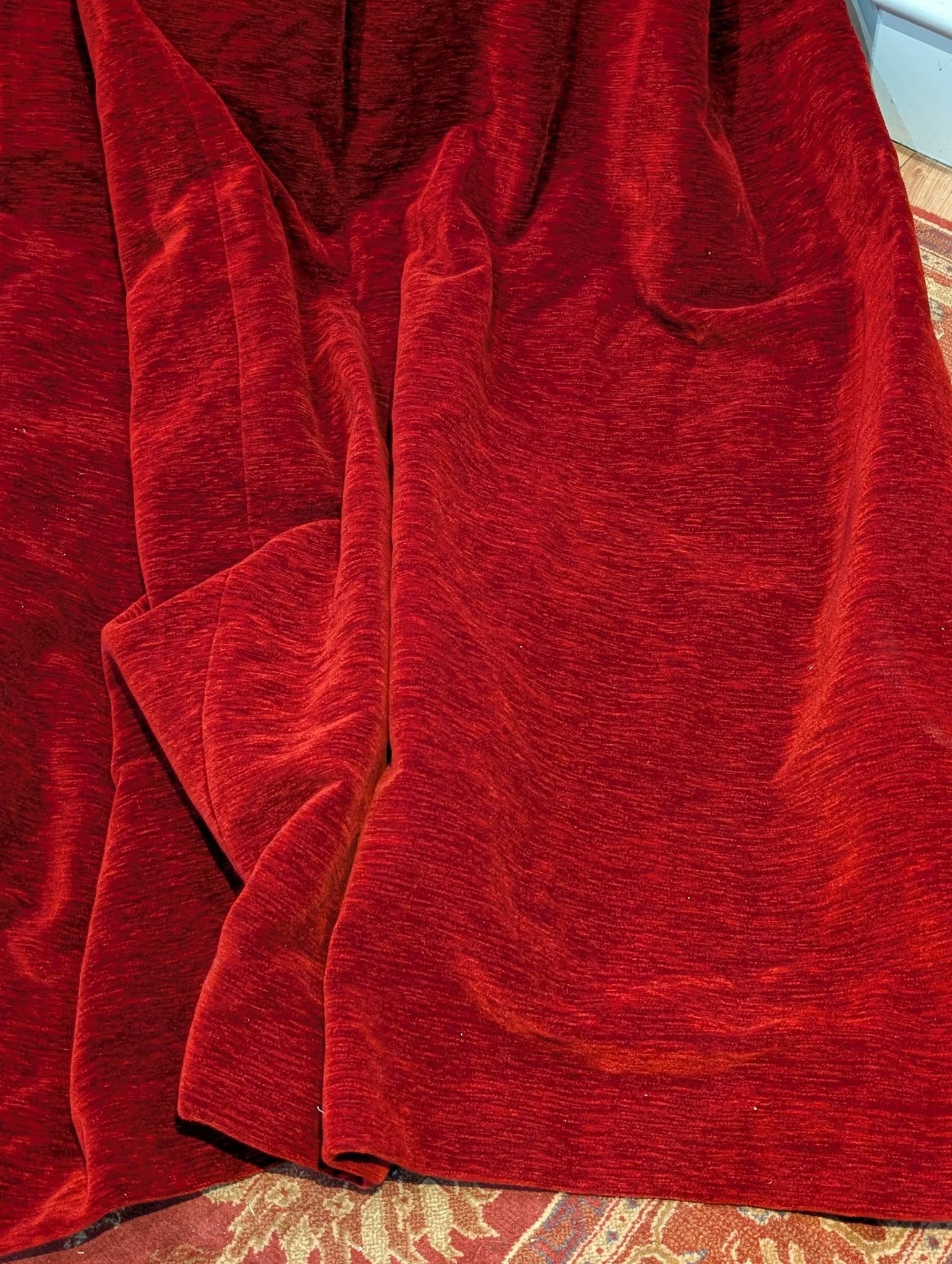 red3 - Divinely Vintage Interiors Red, textured fabric draped and pooled over a patterned rug.