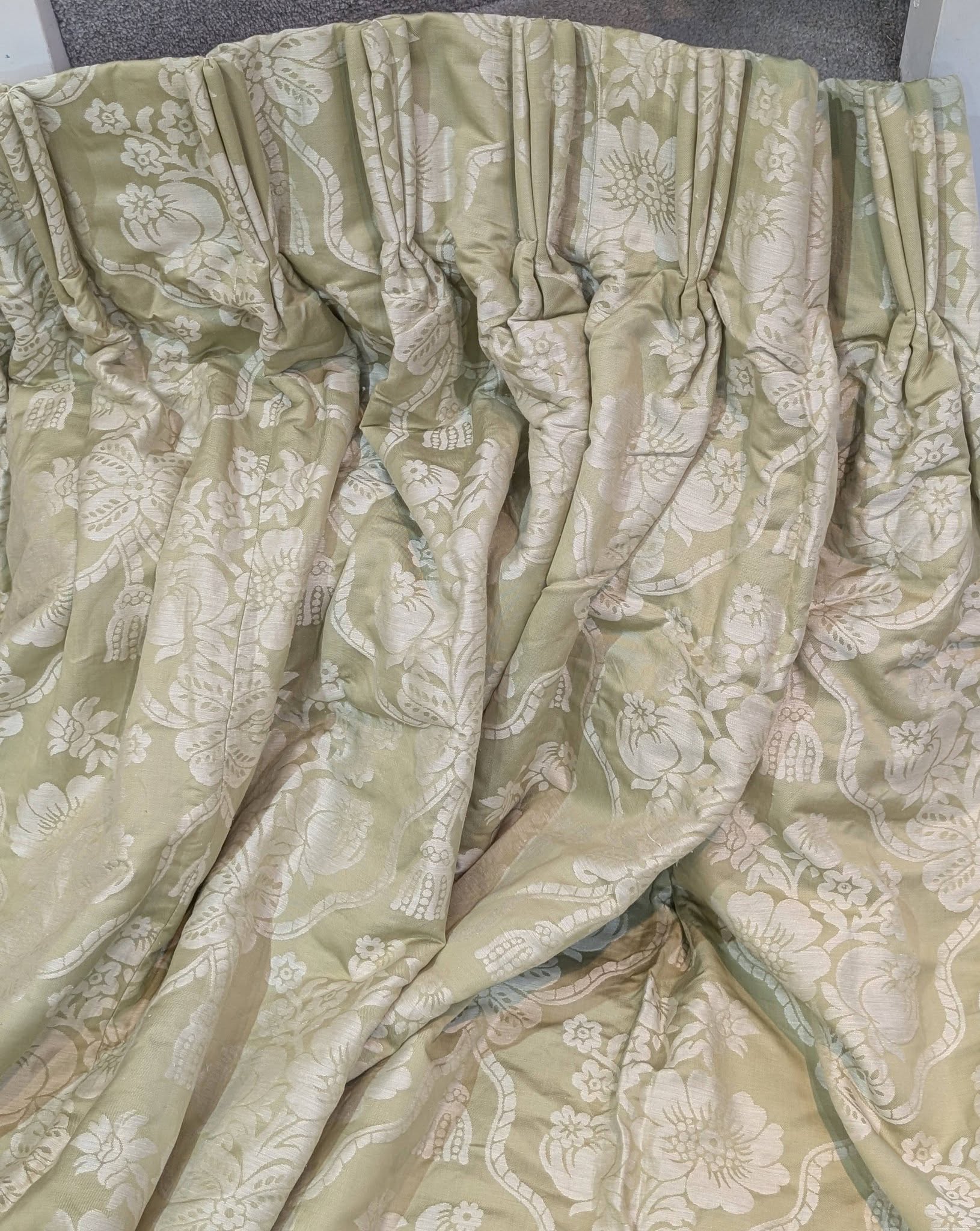 bed6 - Divinely Vintage Interiors Beige-green floral damask bedspread draped and wrinkled over a surface.