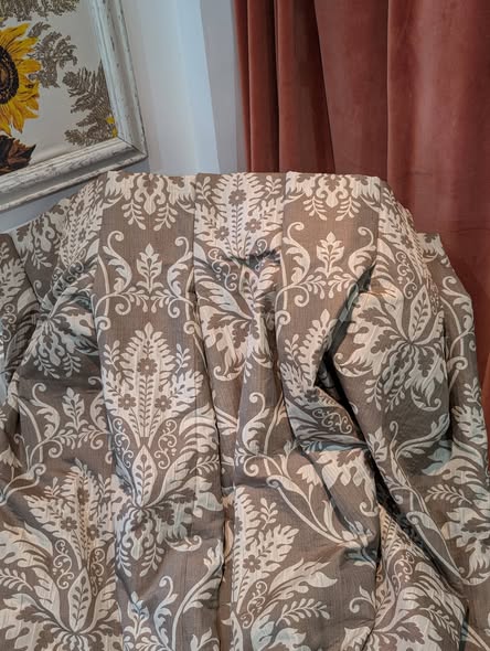 cream11 - Divinely Vintage Interiors Beige damask-patterned fabric draped over furniture; a sunflower painting frame and pink curtains visible in the background.