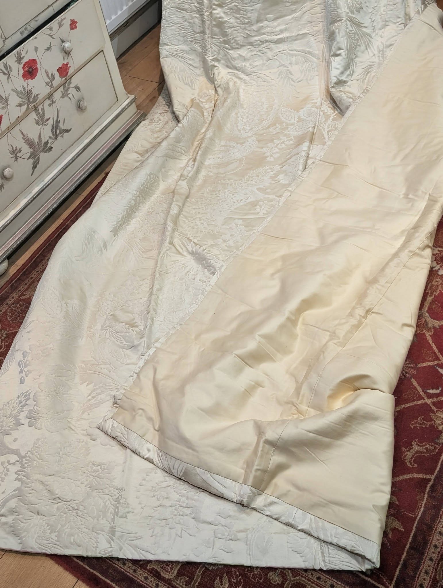 dam3 - Divinely Vintage Interiors Cream satin comforter with floral damask pattern spread on the floor beside a vintage-painted dresser.