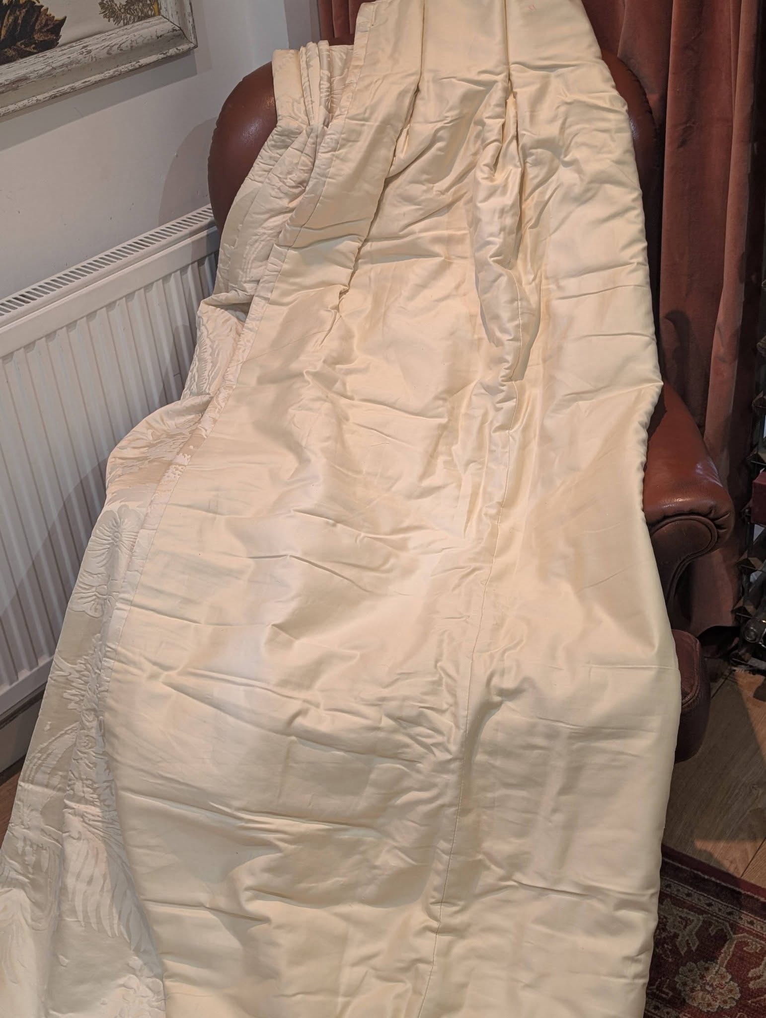 dam6 - Divinely Vintage Interiors Beige quilted blanket draped over a brown leather armchair in a living room near a radiator