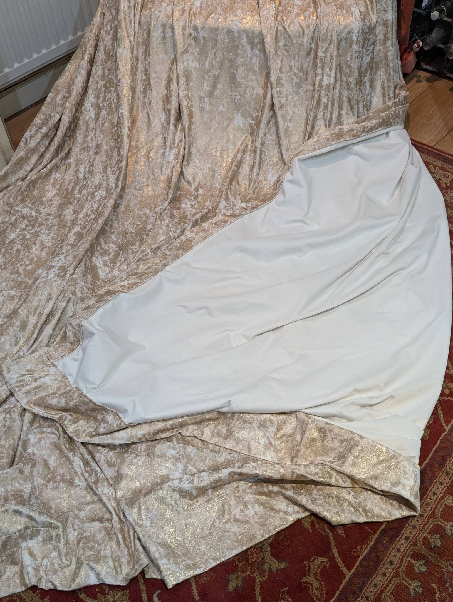 film4 - Divinely Vintage Interiors Crushed beige velvet fabric draped over a white sheet on a red patterned rug.