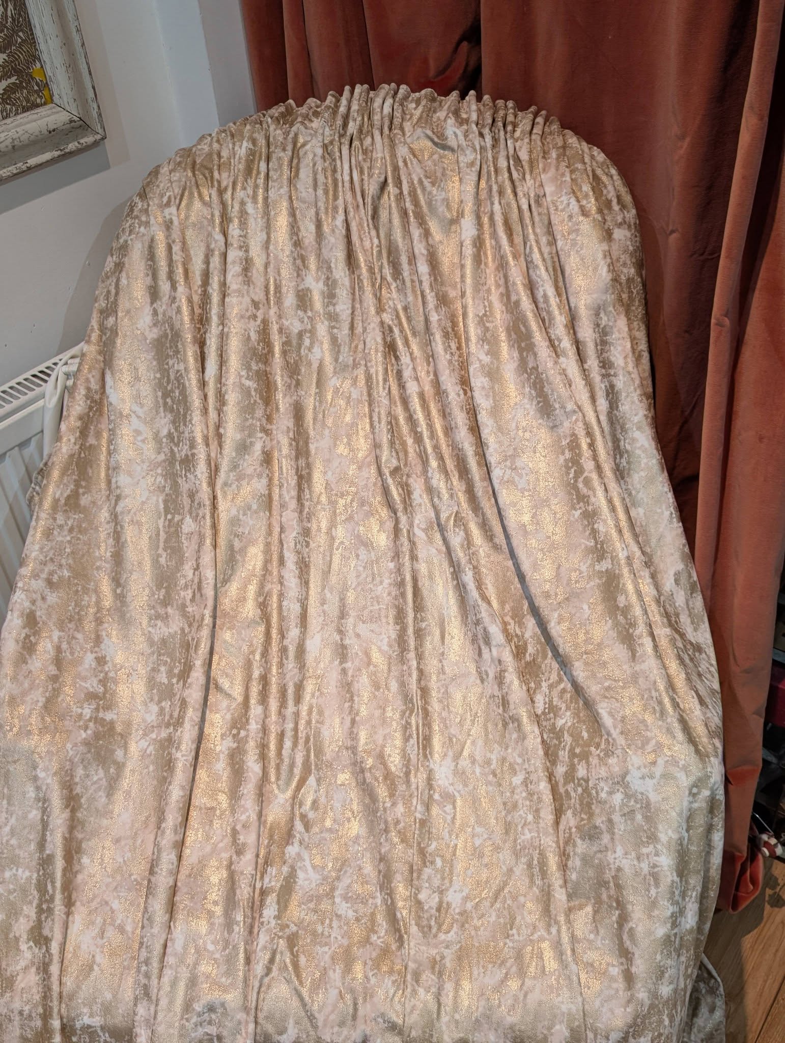film5 - Divinely Vintage Interiors Beige crushed-velvet curtain with a subtle gold shimmer, pleated at the top in a window-dressing setup.