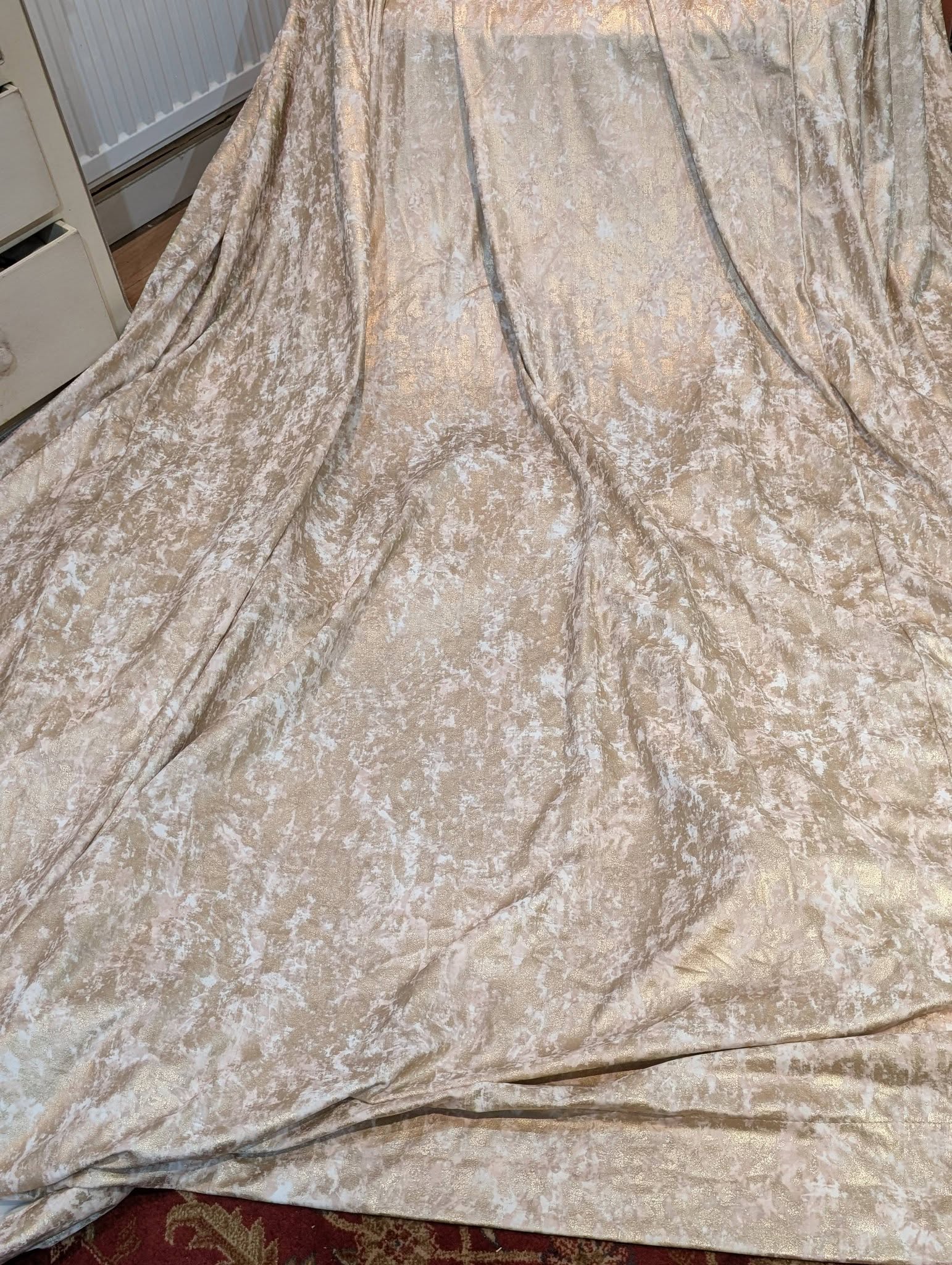 ilm3 - Divinely Vintage Interiors Cream-beige crushed-velvet fabric draped over furniture, creating soft, pleated folds and a metallic sheen pattern.