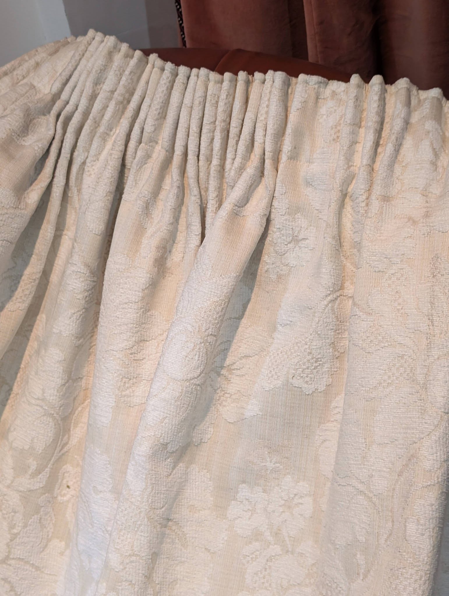 leila7 - Divinely Vintage Interiors Cream-colored textured curtain with a floral pattern and pleated top edge.