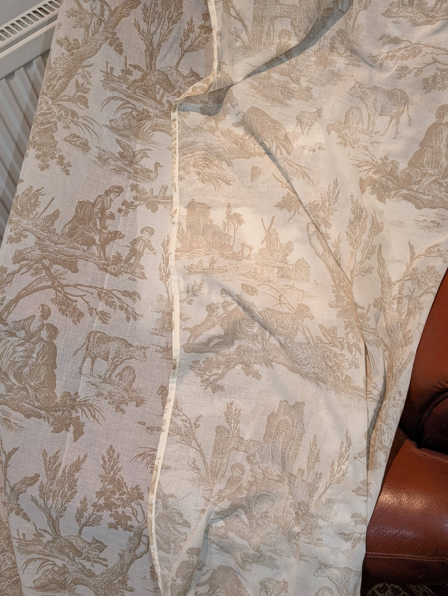 Beige shirt with a classic toile print showing pastoral scenes and hunter figures, button-down front visible